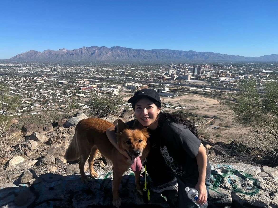 Yuxin Lin with Miso overlooking Tucson and the surrounding Arizona mountains.